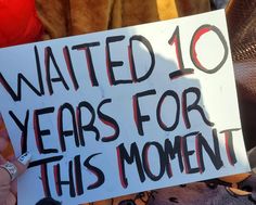 a person holding a sign that says waited 10 years for this moment