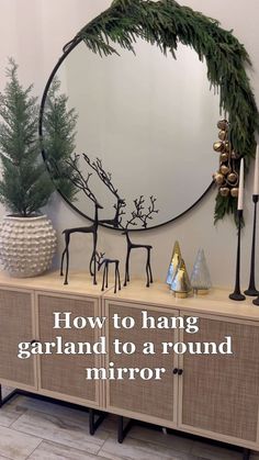 a round mirror sitting on top of a dresser next to a christmas tree and other decorations