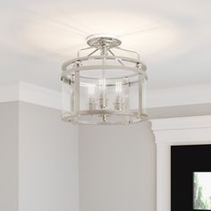 a chandelier hanging from the ceiling in a room with white walls and flooring