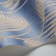 a blue and beige wallpaper with white feathers on it