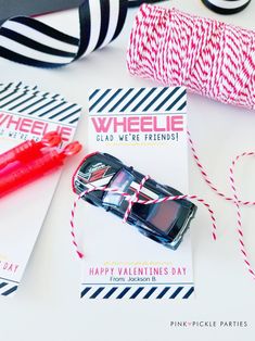 valentine's day gift tags with pink and black striped twine on white table