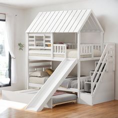 a white bunk bed with a slide and stairs