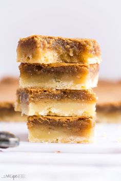 three pieces of cake stacked on top of each other with a spoon in the background