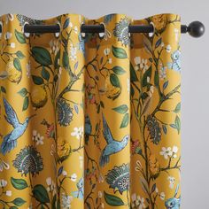 a yellow curtain with birds and flowers on it