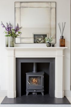 a fire place with a mirror above it