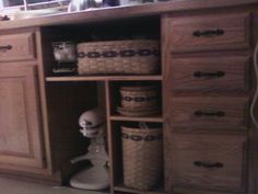 an open cabinet with baskets and other items in it