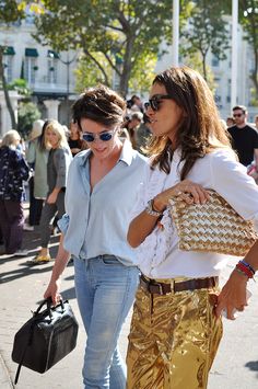 two women walking down the street carrying purses