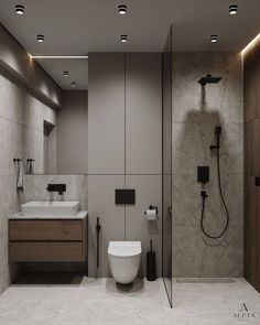 a bathroom with a toilet, sink and shower head mounted to the side of the wall