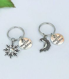 two key chains with charms that say, no matter where you go and the moon is on