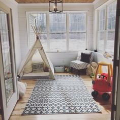 a child's room with a teepee tent and toys