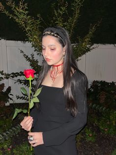 a woman with long hair holding a rose