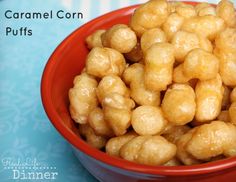 a red bowl filled with caramel corn puffs on top of a blue table