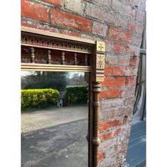 a mirror that is on the side of a brick wall