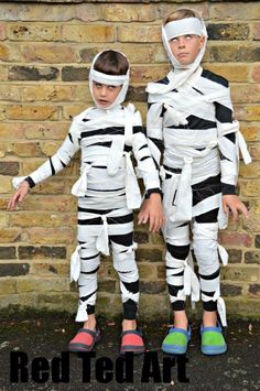 two young boys dressed up in costumes made out of strips of paper and duct tape