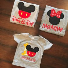 three t - shirts with mickey mouse and minnie mouse on them are sitting on a wooden floor