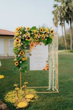 an outdoor ceremony with sunflowers on the grass and a sign that says welcome