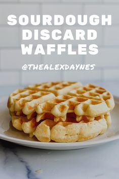 a white plate topped with waffles on top of a counter