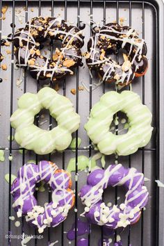 four doughnuts on a cooling rack with sprinkles