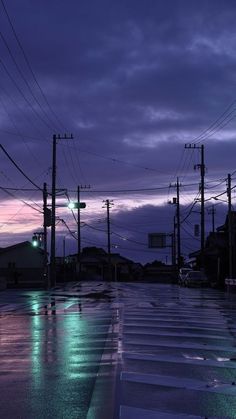 an empty street at night with power lines in the background