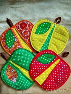 three oven mitts sitting on top of a table