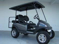 a golf cart parked in front of a white wall