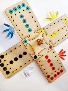 three wooden peg board game pieces with buttons and pins on the top one is missing