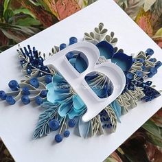 the letter b is surrounded by blue flowers and leaves