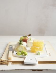 a cutting board with cheese and fruit on it