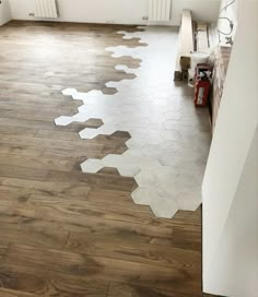 an empty room with hard wood floors and white paint on the floor, in front of a radiator