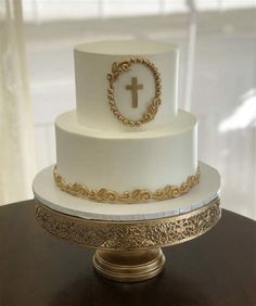 a white and gold wedding cake with a cross on top