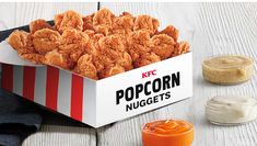 a box of popcorn nuggets next to some dipping sauce