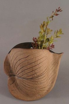 a wooden vase with plants in it on a table