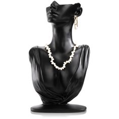 a black mannequin with pearls on it's neck and earrings in the shape of a head