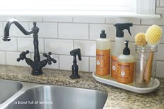 a kitchen sink with soap, toothbrushes and other cleaning products