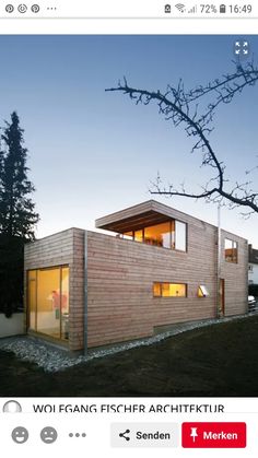 a wooden house sitting on top of a lush green hillside next to a forest at night