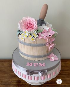 a cake decorated with flowers and a wooden spatula on top of a wood table