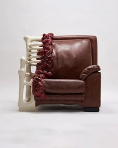 a brown leather chair sitting next to a white radiator with red flowers on it