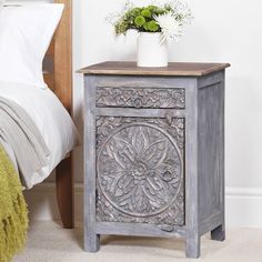 an ornate wooden cabinet next to a bed