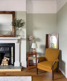 a living room filled with furniture and a fire place in front of a large mirror