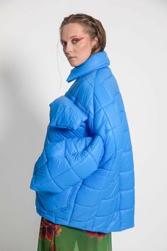 Unisex quilted jacket "Lupinus Light Blue" features a round shoulder and oversized fit for a relaxed, comfortable feel. It's made from lightweight, wrinkle-free polyester and has large pockets, windproof, and water repellent properties. The soft, bold shape makes it a statement piece, and the hypoallergenic synthetic padding adds warmth without compromising style.Size Guide:ONE SIZE (fits to XS-XL)Collar - 51 cmWides middle line - 170 cmBottom line - 140 cmSleeve ends - 57 cmLength from the neck Oversized Quilted Outerwear For Cold Weather, Oversized Quilted Nylon Outerwear, Oversized Quilted Long Sleeve Jacket, Blue Nylon Outerwear With Padded Collar, Blue Nylon Puffer Jacket, Oversized Quilted Long Sleeve Outerwear, Oversized Quilted Outerwear With Long Sleeves, Blue Nylon Puffer Jacket For Cold Weather, Oversized Casual Puffer Quilted Jacket