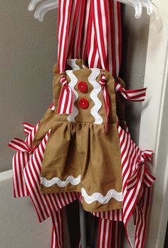 a door hanger decorated with red and white striped paper strips, a gingerbread cookie on the front