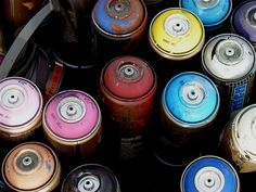 many different colored cans are stacked together