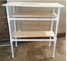 a white shelf with three shelves on top of it and a tile floor in the background