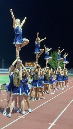 a group of cheerleaders standing on top of each other in the middle of a track