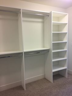 an empty closet with white shelves and carpeted flooring in the middle of it