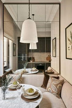 a living room filled with furniture next to a kitchen and dining area in front of a mirror