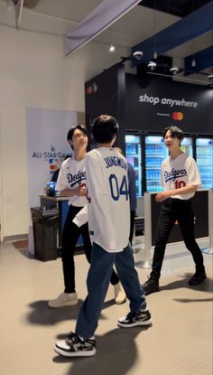 two men are playing wii bowling in a store with another man standing next to them