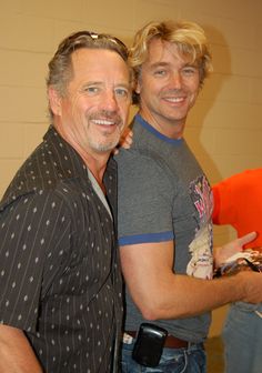 two men standing next to each other smiling