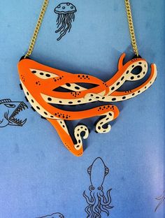 Octopus  🐙 necklace is a fun piece to pair with your outfit. It is a striking piece that will get you noticed for all the right reasons. The necklace is made from cut out black perspex with orange and cream acrylic layered on top. It is linked to a curb chain with jump rings.  If you have any questions drop us a line!💌We are more than happy to help😁 To clean your necklace you can simply wipe with a glasses cloth or soft cloth to remove finger marks. Acrylic is a fragile material so please store in a jewellery box to prevent damage.  As ever for safety please keep away from small children. Bold Resin Jewelry For Gifts, Bold Resin Jewelry For Gift, Unique Orange Necklace For Party, Bold White Jewelry For Gifts, Bold White Jewelry For Gift, Handmade Bold Necklace For Party, Bold Handmade Necklace For Party, Orange Resin Jewelry For Party, Trendy Handmade Resin Necklace