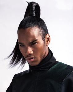 a man with a black top knoted into his hair